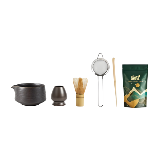 Tea-making set with ceramic pitcher, small pot, whisk, strainer, and matcha powder package on a white background